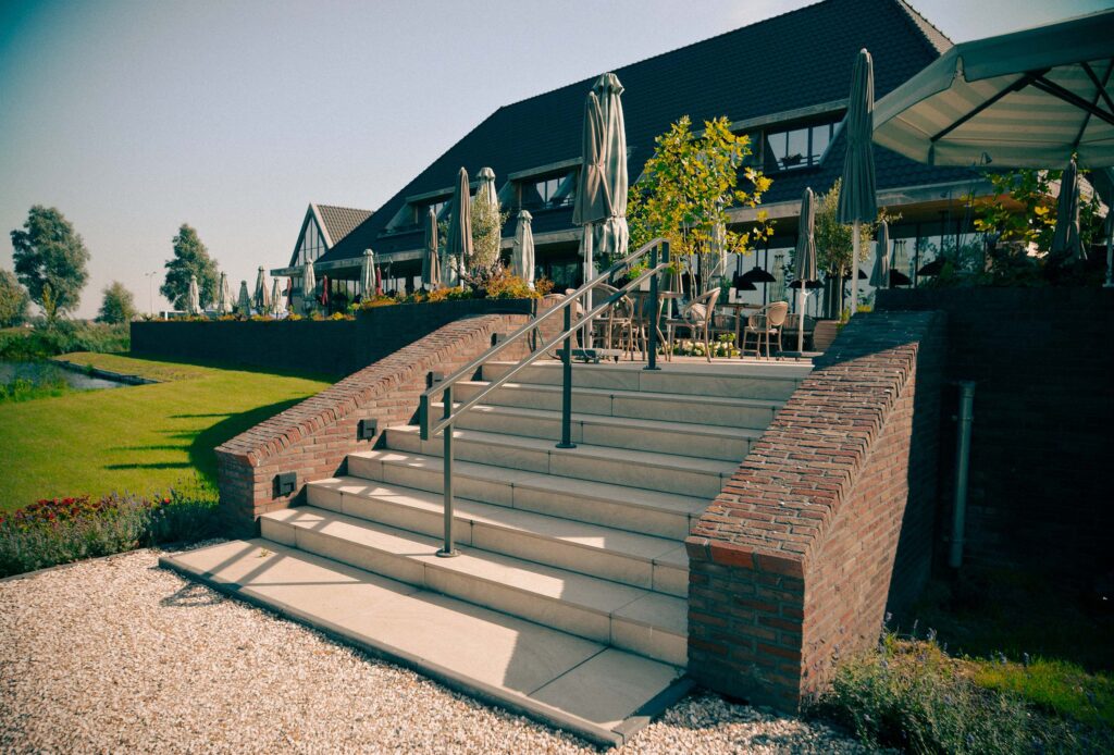 Brede trap met stalen leuningen naar het terras van Van der Valk Volendam
